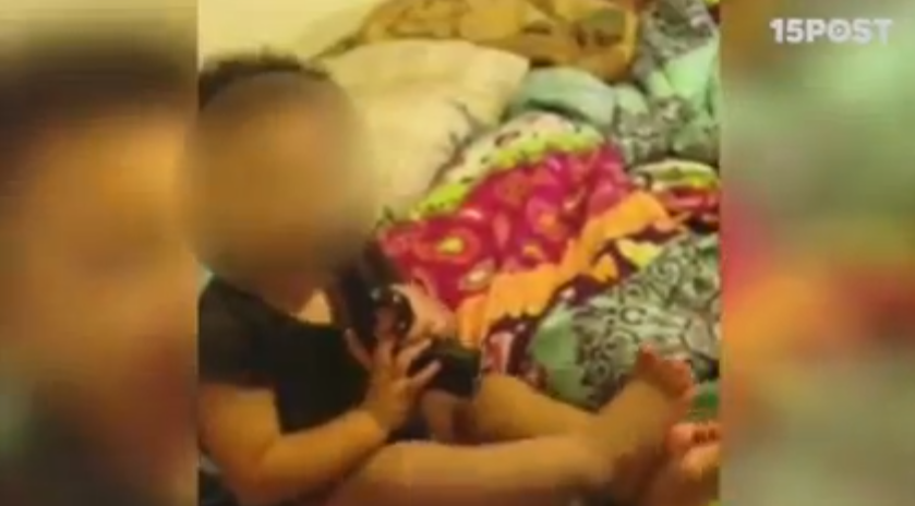 padres animan a un bebé a meterse pistola en la boca