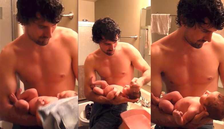 padre bañando a su bebe