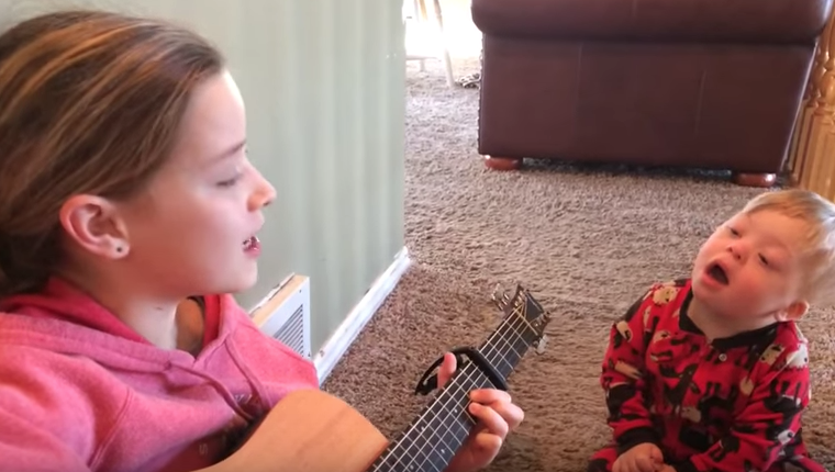niña cantando a su hermano sindrome de down