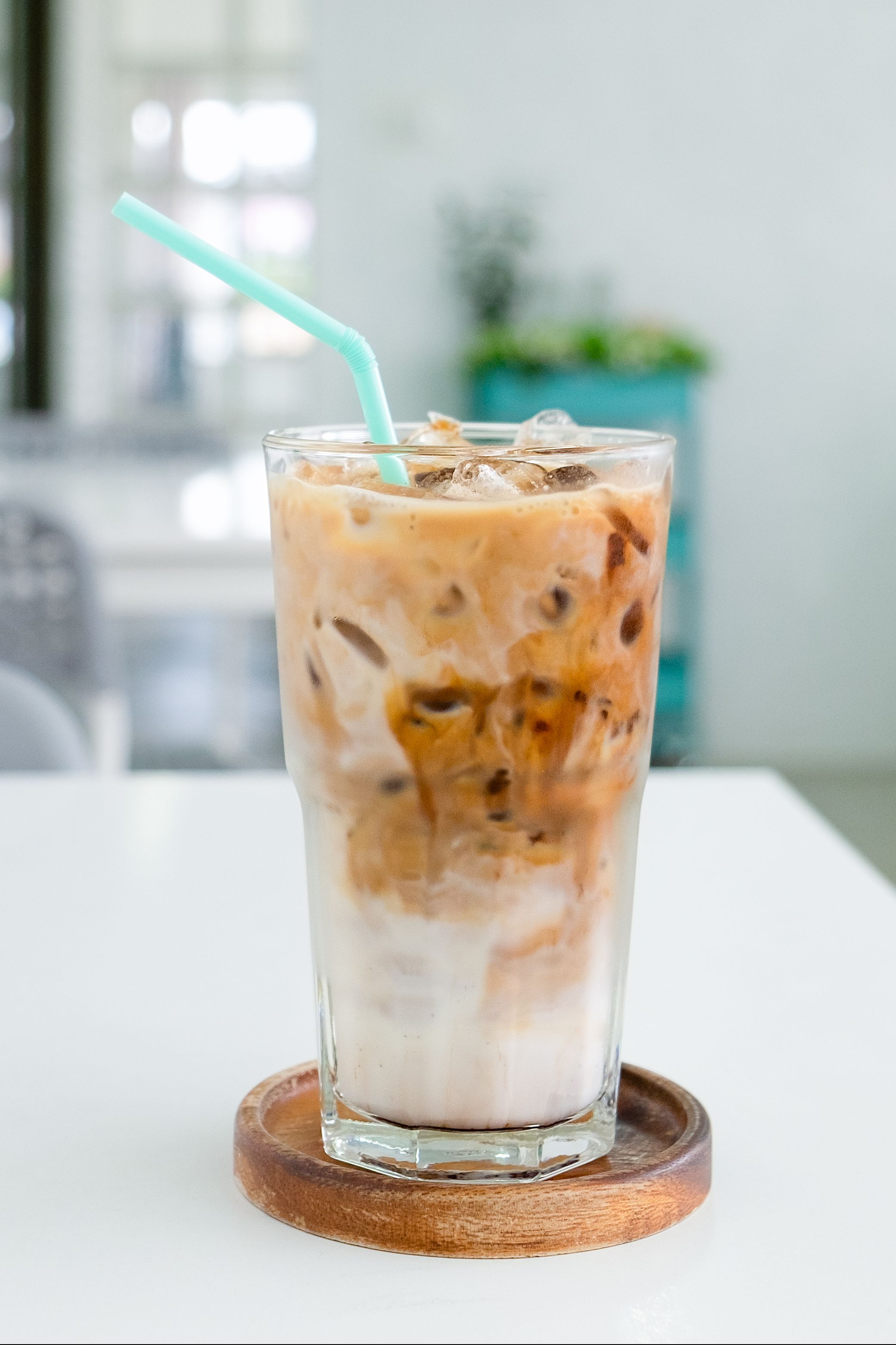 a glass of ice coffee on the white table in coffee shop