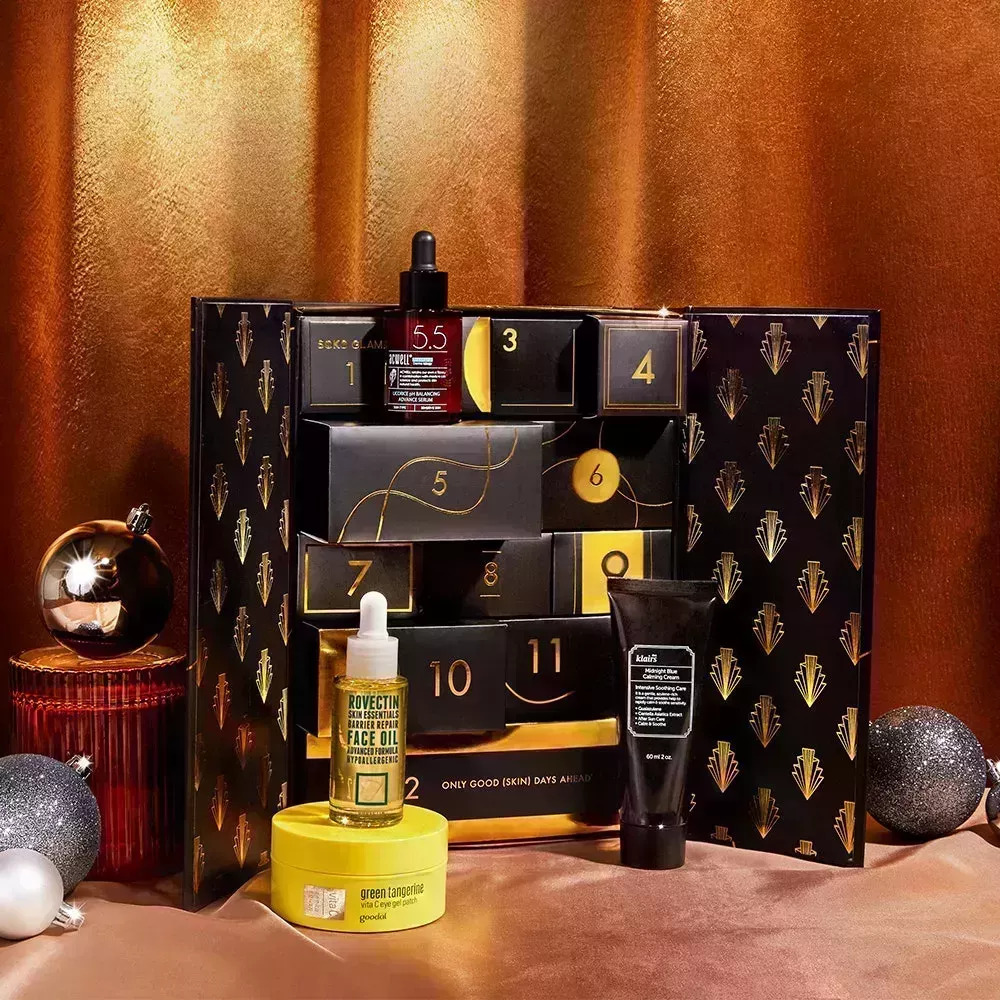 Soko Glam Advent Calendar on a gold background with silver Christmas ornaments