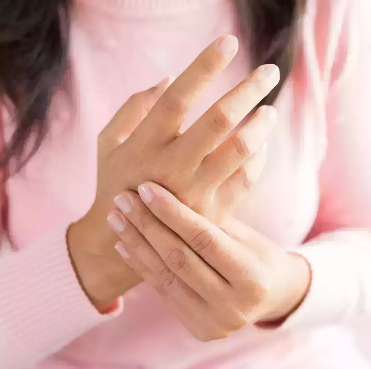 closeup woman sitting on sofa holds her wrist hand injury feeling pain health care and medical concept