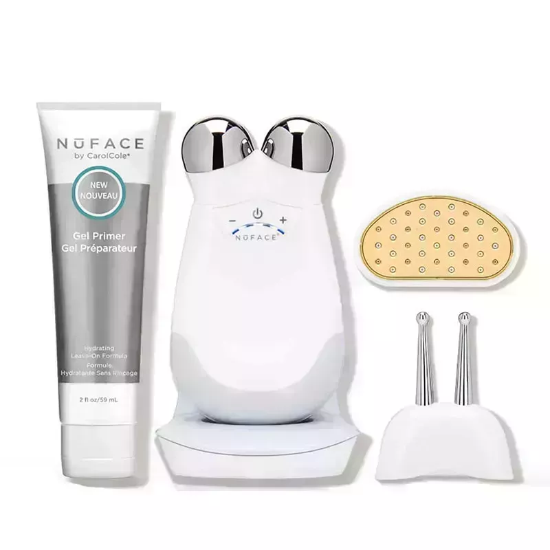 A photo of the NuFace Trinity device with two attachments and a bottle of microcurrent gel primer on a white background