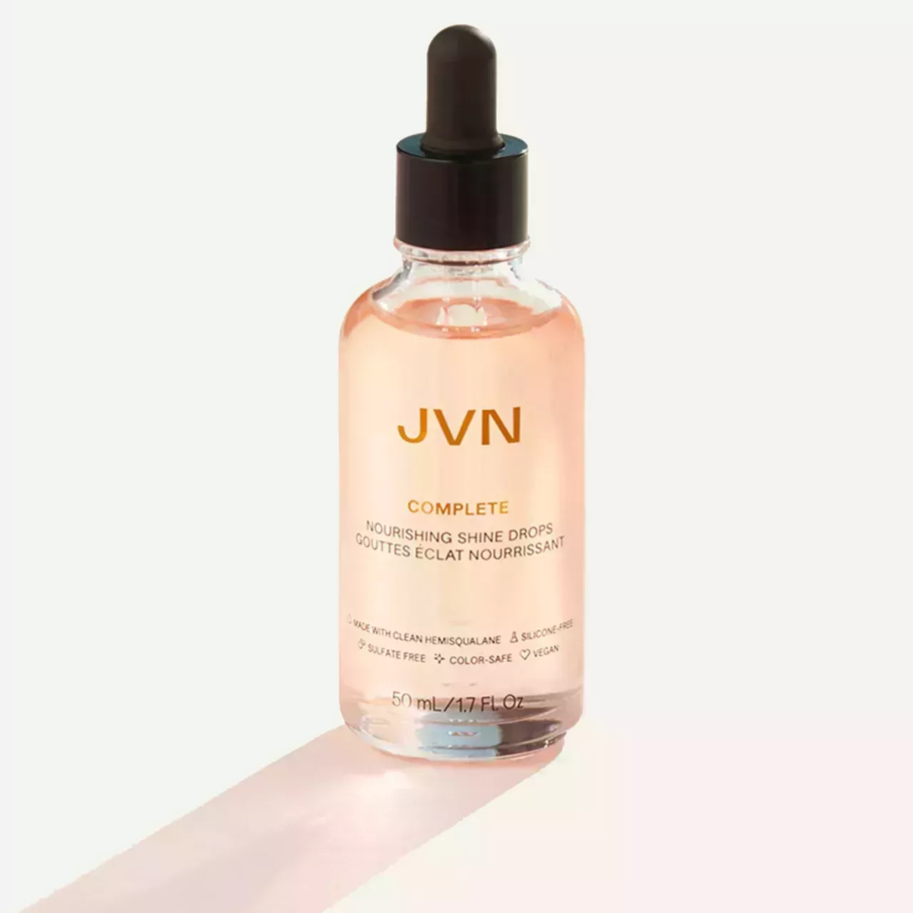 Bottle of JVN nourishing shine drops on a greige background