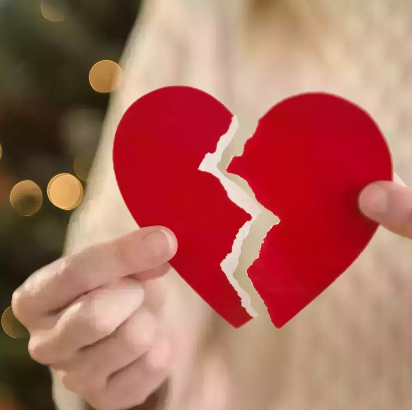 studio shot of female's hands holding broken heart