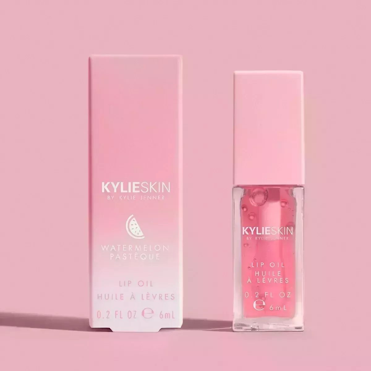 Pink lip oil with a pink lid and pink background