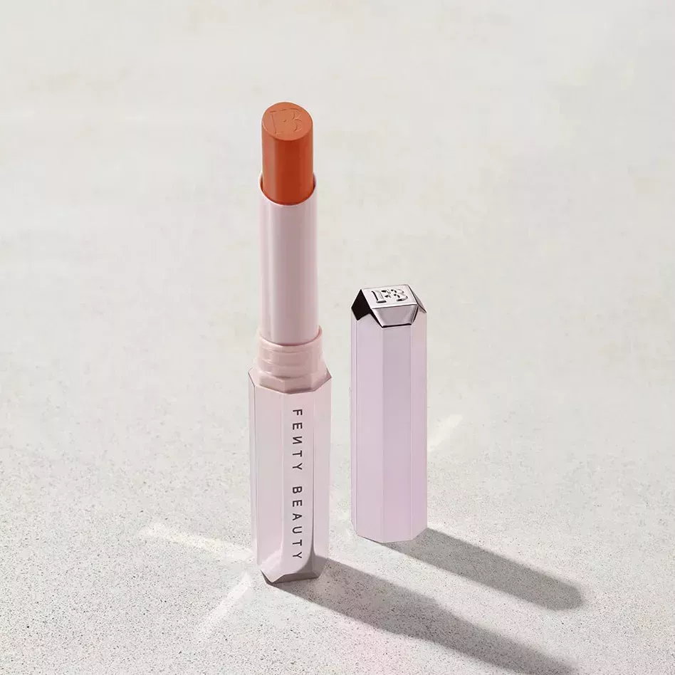 Brick Red Fenty Beauty Mattemoiselle Plush Matte Lipstick in Freckle Fiesta on gravel background