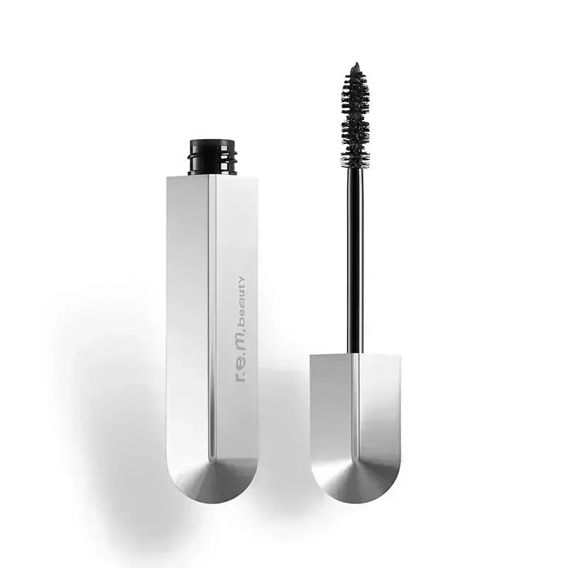 An open silver tube of the black r.e.m. beauty Flourishing Volumizing Mascara with mascara wand on a white background