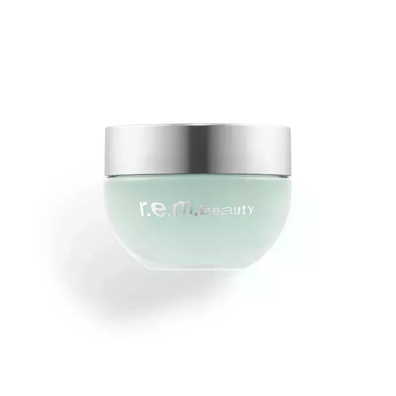 A small clear pot of the r.e.m. beauty Full Night's Sleep Cooling Blurring Undereye Balmon a white background