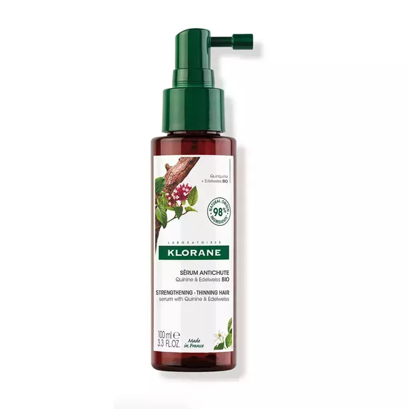 A brown and green bottle of the Klorane Strengthening Serum on a white background