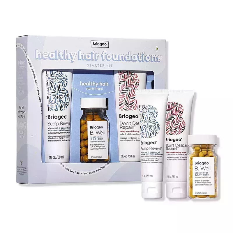 The Briogeo Healthy Hair Foundations Starter Kit, including two mini-sized tubes and one glass jar filled with yellow pills, on a white background