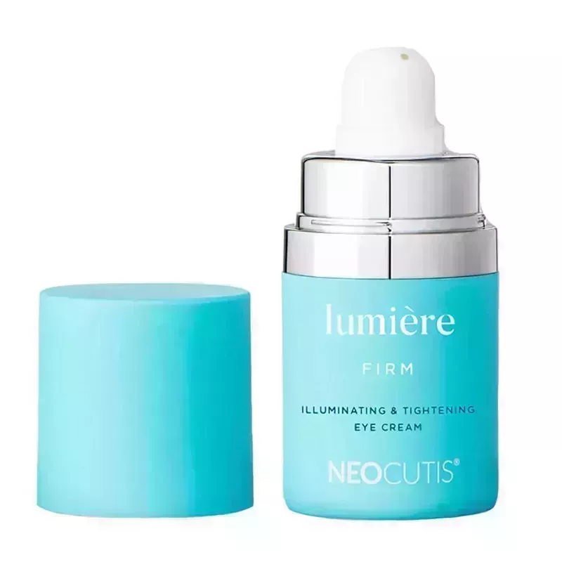 A blue pump bottle of the Neocutis Lumière Firm Illuminating Tightening Eye Cream on a white background