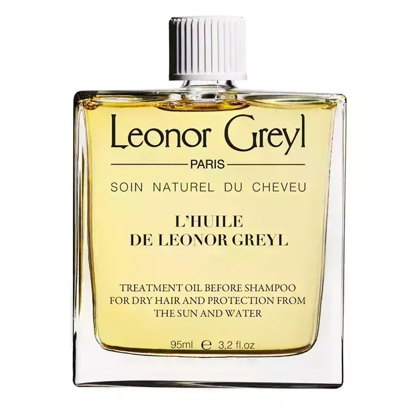 A clear glass square bottle of the Leonor Greyl Huile de Leonor Greyl Shampoo Treatment on a white background