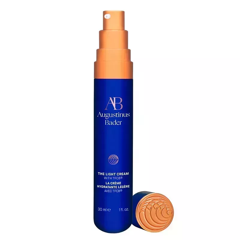 A navy blue metal tube of the Augustinus Bader The Light Cream on a white background