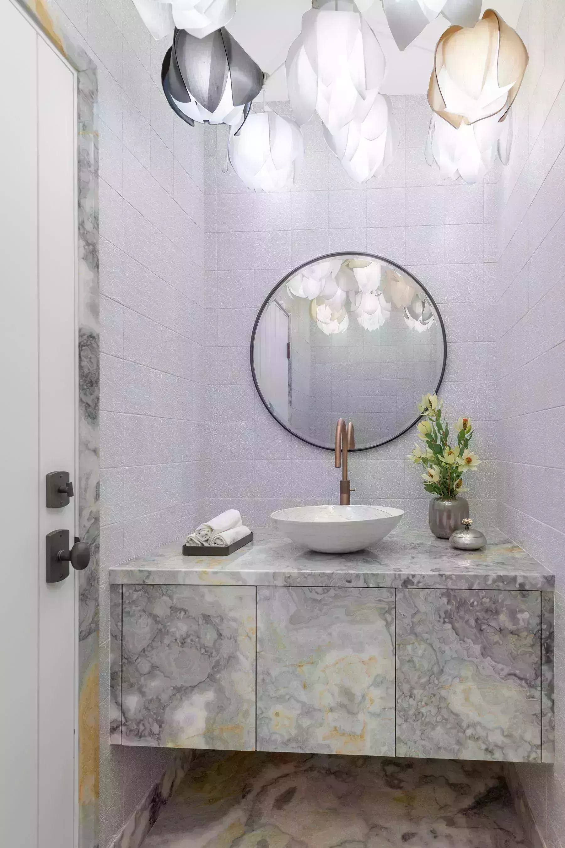 marble vanity with round mirror and decorative lights