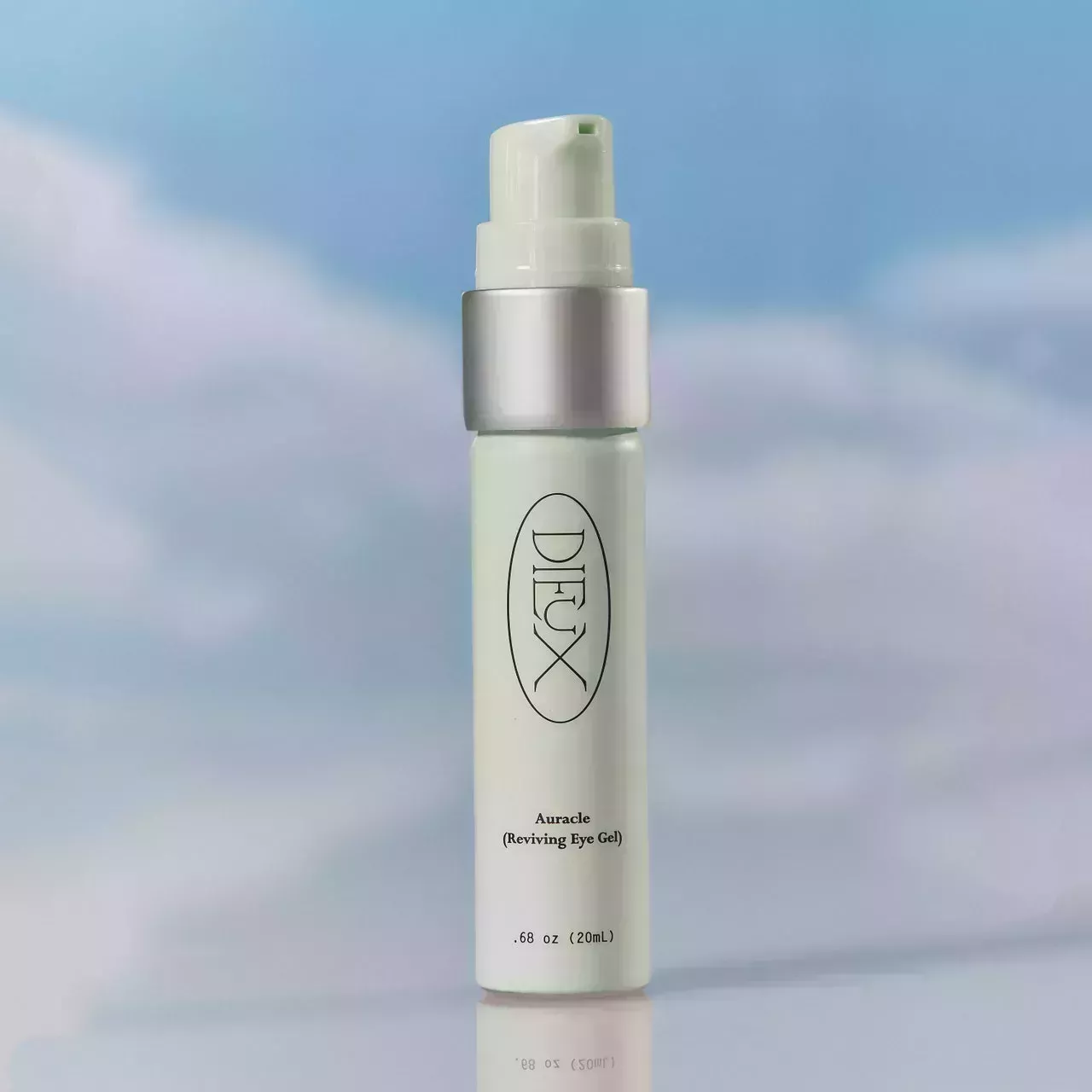Dieux Skin Auracle Eye Gel pale green tube on cloudy sky background