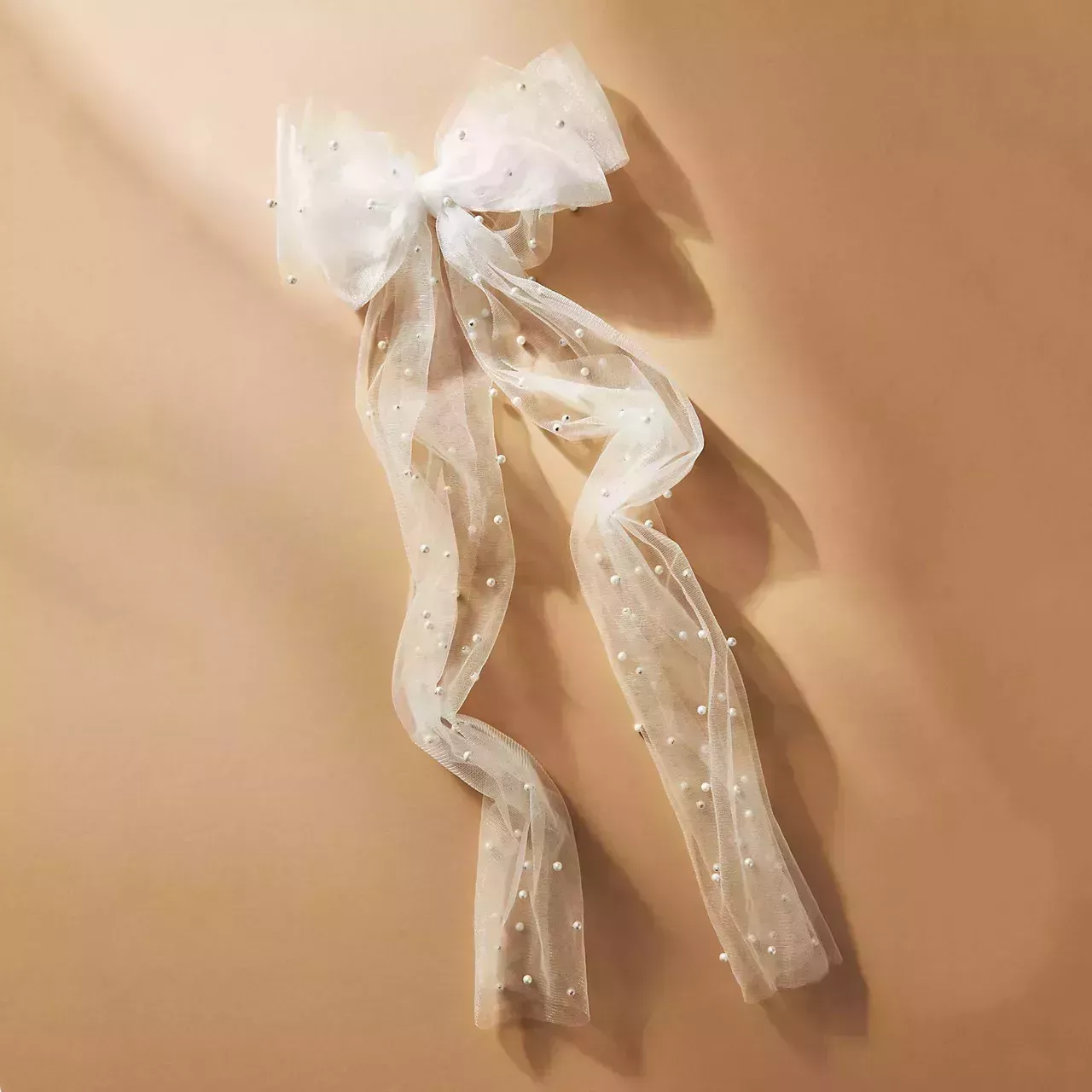 Anthropologie Simply Nova Pearl Bow white tulle bow with pearls on tan background