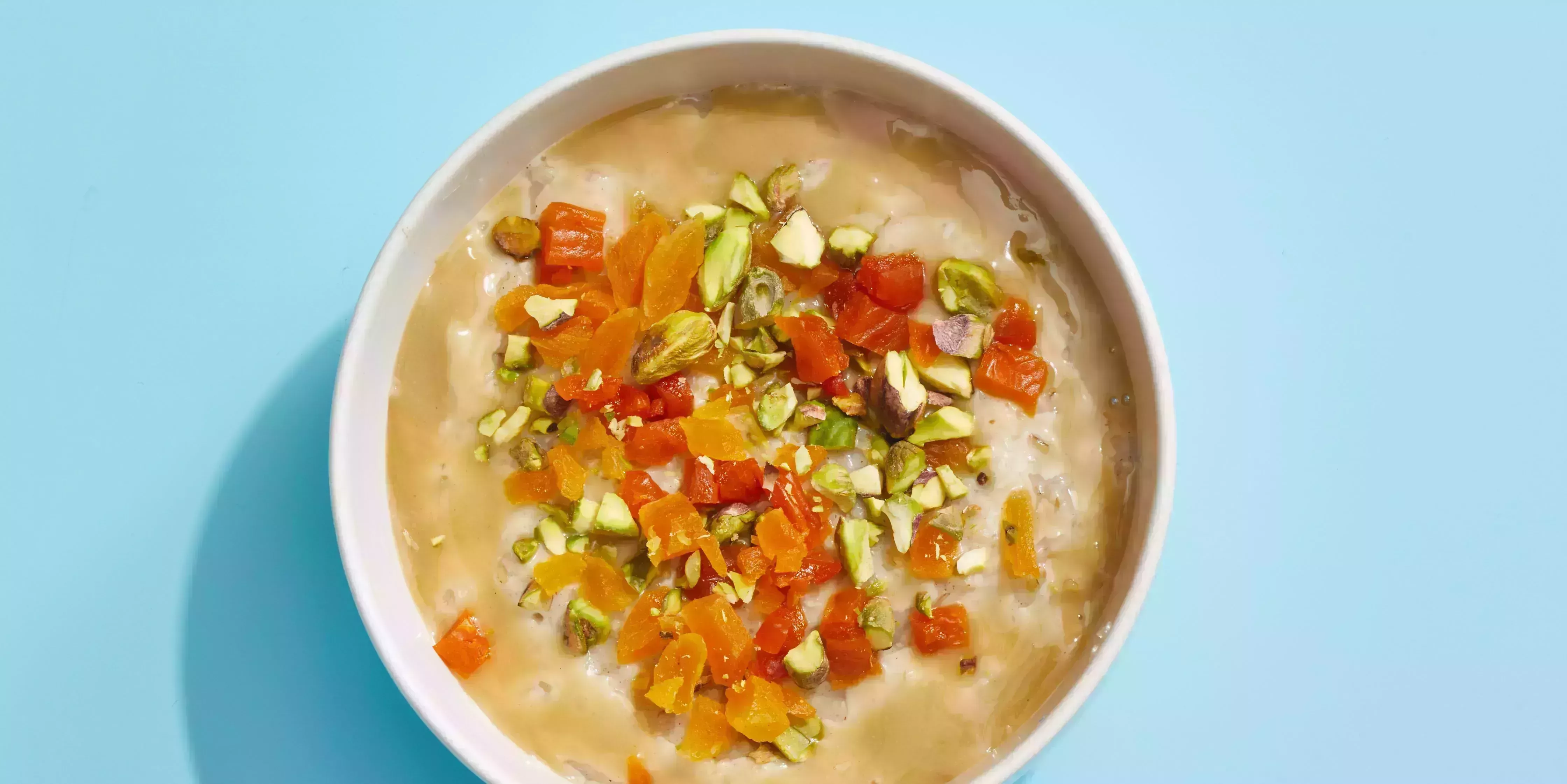 oatmeal with pistachios and apricots on a blue background