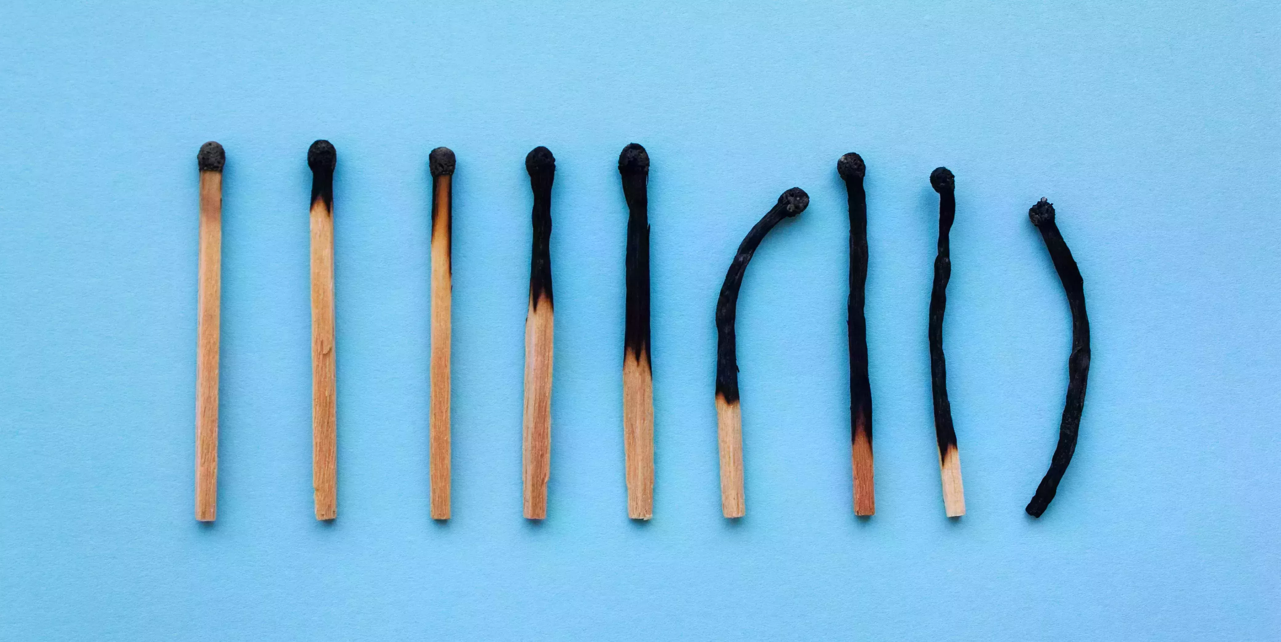 burned matches in a row on a blue background