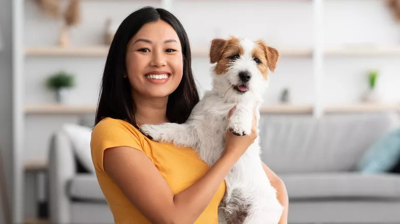 mujer feliz sosteniendo un perro