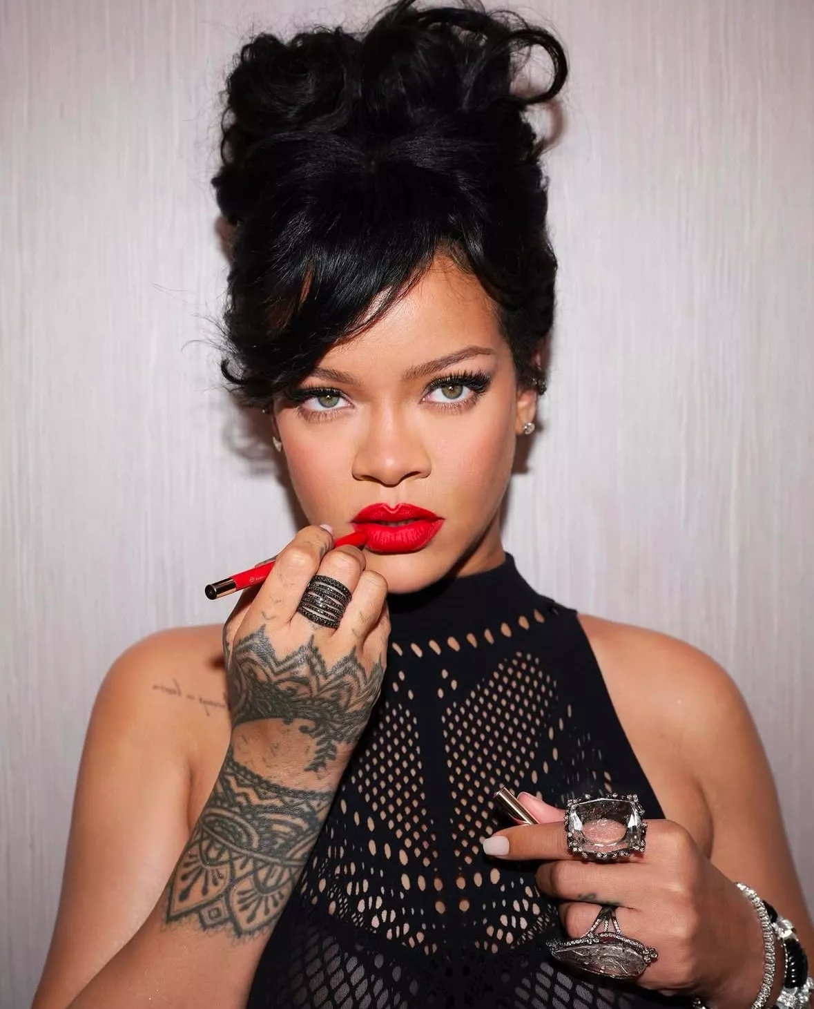 Rihanna con su labio rojo y moño desordenado