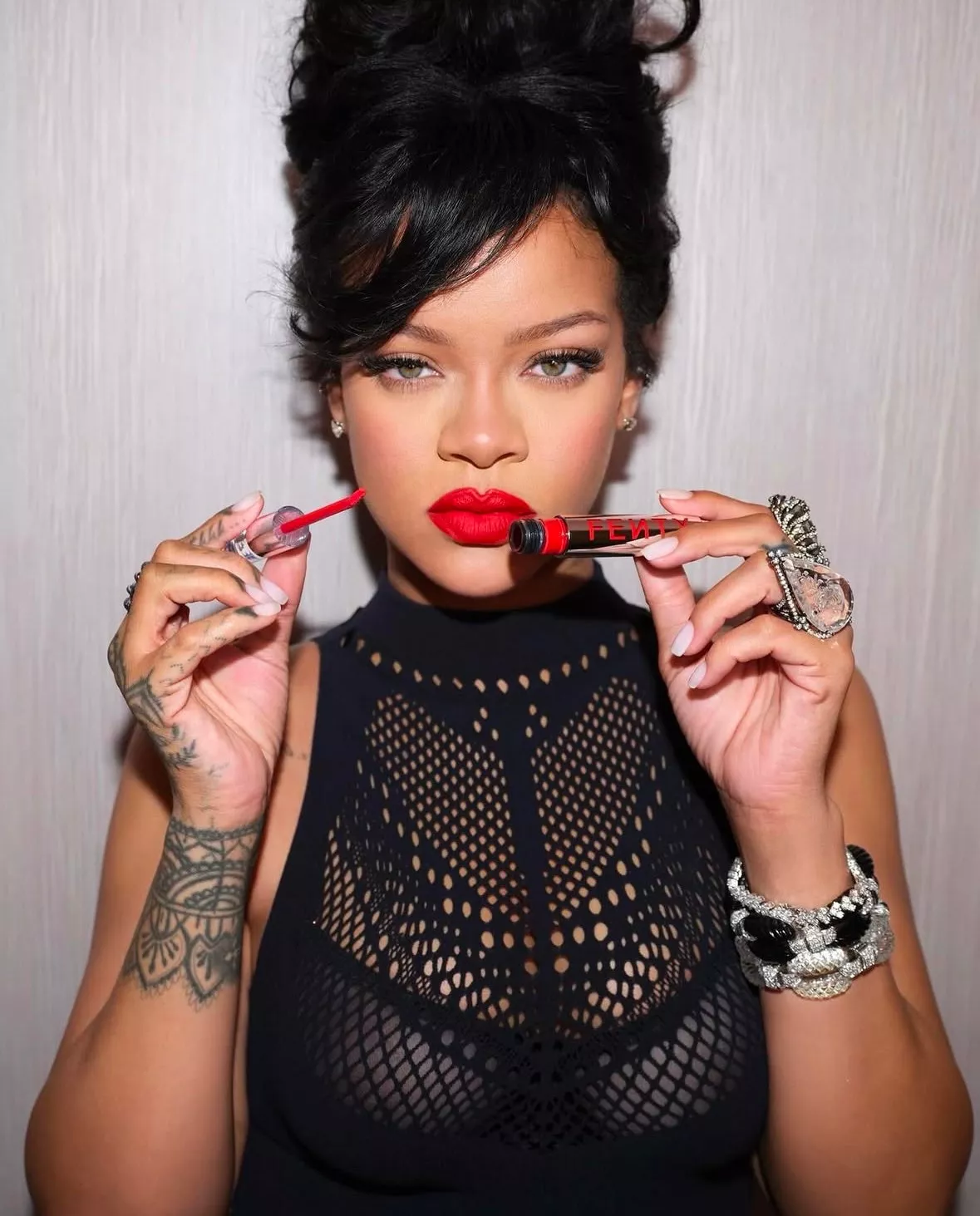 Rihanna mostrando su look con labio rojo