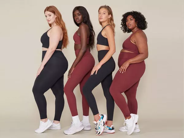 Cuatro personas de diferentes tipos de cuerpo usando ropa de Girlfriend Collective.