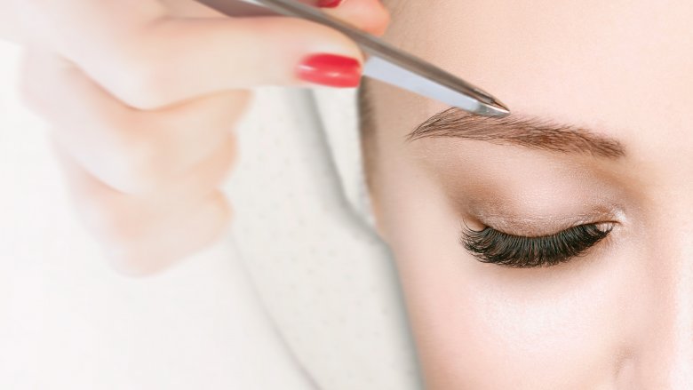 mujer depilando encima de la ceja