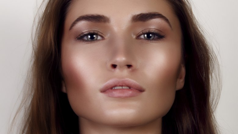 mujer con iluminador debajo de las cejas